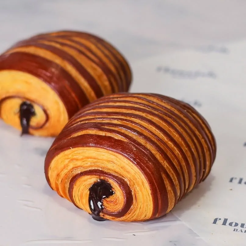 Two chocolate-striped pain au chocolat with glossy chocolate centres